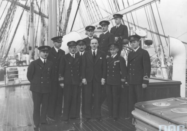 Kadra oficerska \"Daru Pomorza\" w rejsie dookoła świata. Fotografia wykonana przy okazji wizyty na statku posła nadzwyczajnego i ministra pełnomocnego Polski w Japonii Michała Mościckiego. Stoją od lewej: IV oficer Stanisław Kosko, lekarz dr Jarosław Truszkowski, komendant Konstanty Maciejewicz, radiotelegrafista Alojzy Kwiatkowski, minister Michał Mościcki, I oficer Tadeusz Meissner, kapelan ks. Wojciech Główczewski. Stoją za nimi od lewej: III oficer Stanisław Rowiński, II oficer Konstanty Kowalski, V oficer Stefan Gorazdowski. (ze zbiorów NAC)